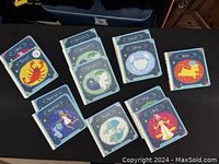 Top view of 10 zodiac books arranged showing different illustrations: Cancer, Sagittarius, Taurus, Aries, Libra, Leo, Scorpio, Aquarius, Pisces and Virgo.