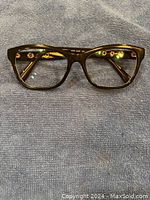 Front view of black Versace eyeglasses with rectangular lenses and gold circular accents on temples.