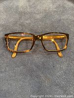 Front view of brown Versace eyeglasses on grey fabric background