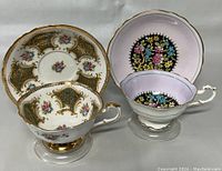 Two vintage Paragon teacups and matching saucers with intricate floral and gold designs, showcasing the lot's overall condition and decorative details.
