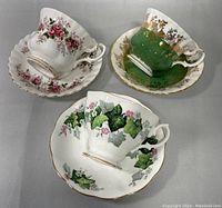 Top view of the three teacups with matching saucers showing floral patterns and gold trim