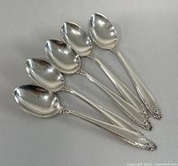 Set of 5 sterling silver place spoons arranged side-by-side showing full length and design of handles and bowls.