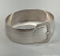 Front angled view of the sterling silver buckle bangle cuff bracelet with etched details.