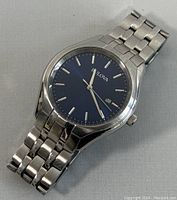 Close-up photo of the Bulova men's wristwatch showing blue dial with silver-tone markers and stainless steel linked bracelet.