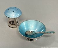 Three-quarter view of salt dish, enamel spoon, and pepper shaker showing overall design and color.