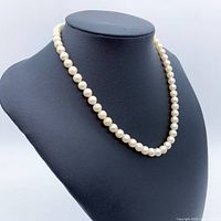 Necklace displayed on black bust, front view