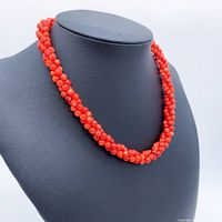 Front view of twisted red coral bead necklace on black bust
