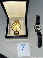 Two watches pictured side by side, one in presentation box, one on table