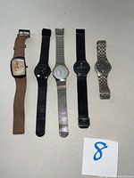 Group shot of five Skagen watches laid side by side on white background