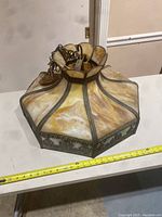 Full view of the 1920s antique hanging dome slag glass lamp showing shape, brass chain, and marbled glass panels.