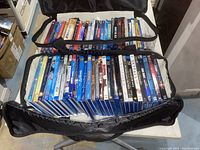 Photo showing two layers of Blu-ray DVDs inside a black carrying bag on a table