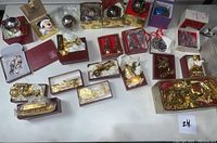 Overview of gold-tone Reed & Barton ornaments including musical instruments and vehicles in boxes, and other holiday-themed ornaments.
