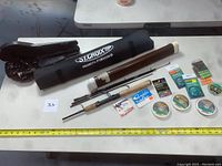 Fishing rods, reels, lines and hooks laid out on a table showing Daiwa, St. Croix rods and fishing accessories