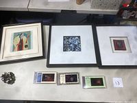 Photo showing the three framed artworks and three Disney motion cell collectibles laid out on a table.