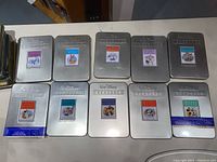 Ten silver Walt Disney Treasures tins arrayed on a table; shows multiple titles and overall condition of tins