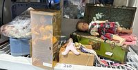Photo showing multiple dolls and carrying cases with doll accessories.