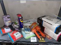 Overview photo showing all items in the lot arranged together including timers, WD-40, lint rollers, hooks, filters, locks, and storage bags.