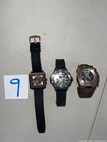 Three Stuhrling Original watches side by side on flat surface with lot number card.