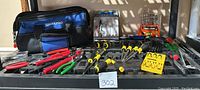 Full view of laid out tools including WorkPro tool bag, various pliers, red and green handled, cable cutters, wire strippers, Stanley yellow and black screwdrivers, Wisdom 5-piece air blow gun kit, Black & Decker drill bit set, and small levels.
