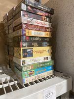 Stack of assorted unopened VHS tapes showing titles such as Saving Private Ryan, Hamlet, Shakespeare in Love, and others.