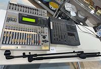 All three items displayed on table: mixer, recorder, mic stand