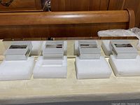 Photo of the bathroom light fixture showing four rectangular frosted glass lights with chrome accents mounted on a polished chrome bar, laying on white foam padding.