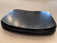 Black laptop lap pad with curved hard surface and padded base.