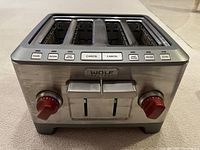 Front view showing stainless steel housing, four slots, red knobs and function buttons