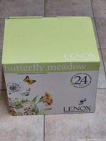 Box front with branding and butterfly floral design showing 24-piece set info and suitability for oven, dishwasher, microwave, freezer.