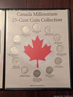 Front image of the Canada Millennium 25-Cent Coin Collection folder with all 12 coins visible surrounding a large red maple leaf, each coin representing a month and themed design.