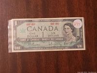 Front side of the 1967 Centennial Canadian one dollar bill showing Queen Elizabeth II and denomination details.