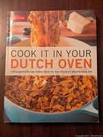 Front cover of the cookbook, showing the title 'Cook It in Your Dutch Oven' with an image of pasta in a Dutch oven.