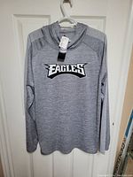 Front view of grey men's hoodie with Philadelphia Eagles logo on chest.
