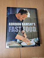 Front cover of the hardcover cookbook with image of Gordon Ramsay and the title 'Gordon Ramsay's Fast Food'.