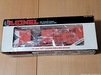 Front side of the box, showing the orange Lionel CP Rail boxcar in original packaging with mention of '0' and '027' gauge rolling stock.