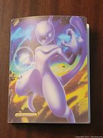 Front cover of Pokemon binder featuring Mewtwo character artwork on a colorful background.