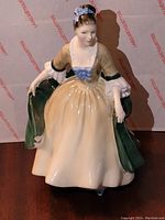 Front view of Royal Doulton Elegance HN 2254 porcelain figurine showing detailed dress and green cloak.