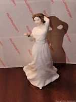 Front view of Royal Doulton 'With Love' porcelain figurine, showing woman holding a pink flower and touching her hair.