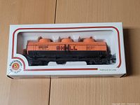 Front view of the Shell HO scale model train oil tanker in original clear display box showing the orange tanker with black base and Shell logo.