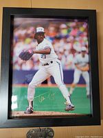 Full view of the framed photo of Juan Guzman in Blue Jays uniform pitching on field.