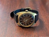 Front view showing dark dial, stick markers, hands, date window and overall case condition