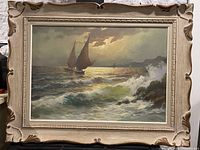 Full view of the framed antique oil painting showing seascape with sailboats, waves, rocky shore, and cloudy sky.