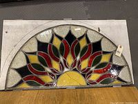 Full view of the half-circle stained glass panel showing the entire design and structure on wooden board.
