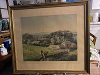 Overall framed vintage art print showing rural homestead landscape scene.