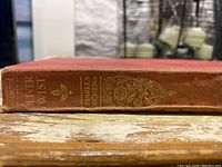 Photo of the spine of the hardcover Oliver Twist book showing the title and author embossed in gold on reddish-brown cloth cover.