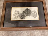 Framed pencil art showing two wolf heads and two wolf paw prints, centered and clearly visible.