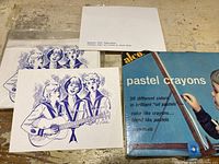 Photo showing vintage greeting cards with blue printed girls and a white paper with text