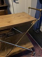 Side view showing two wood shelves with brass frame and bottle holders