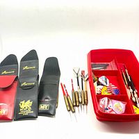 Group view of three dart wallets, five darts, and red organizer tray with contents