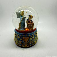 Front view of snow globe showing Pinocchio and Blue Fairy inside globe